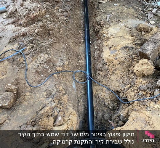 צינור שחור בתעלה באדמה עם את חפירה כתום